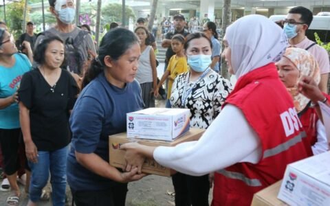 DSWD staff handing relief goods to families, similar to DSWD AICS assistance