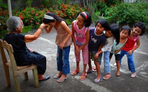Children doing mano to an elderly Filipino woman who may receive a social pension