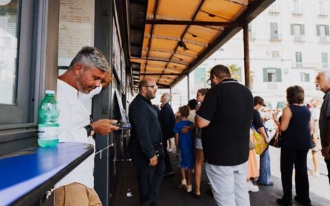 People waiting in line at a bus ticket window