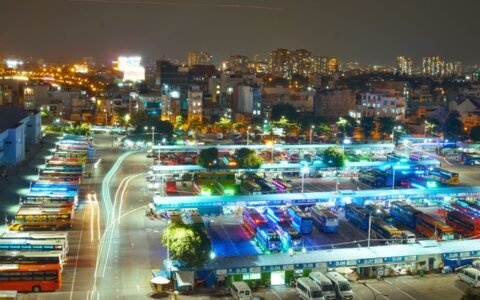 A brightly lit urban bus terminal at night