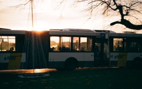 A coach bus driving on the road at sundown