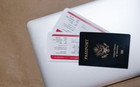 Passport and travel tickets resting on a laptop
